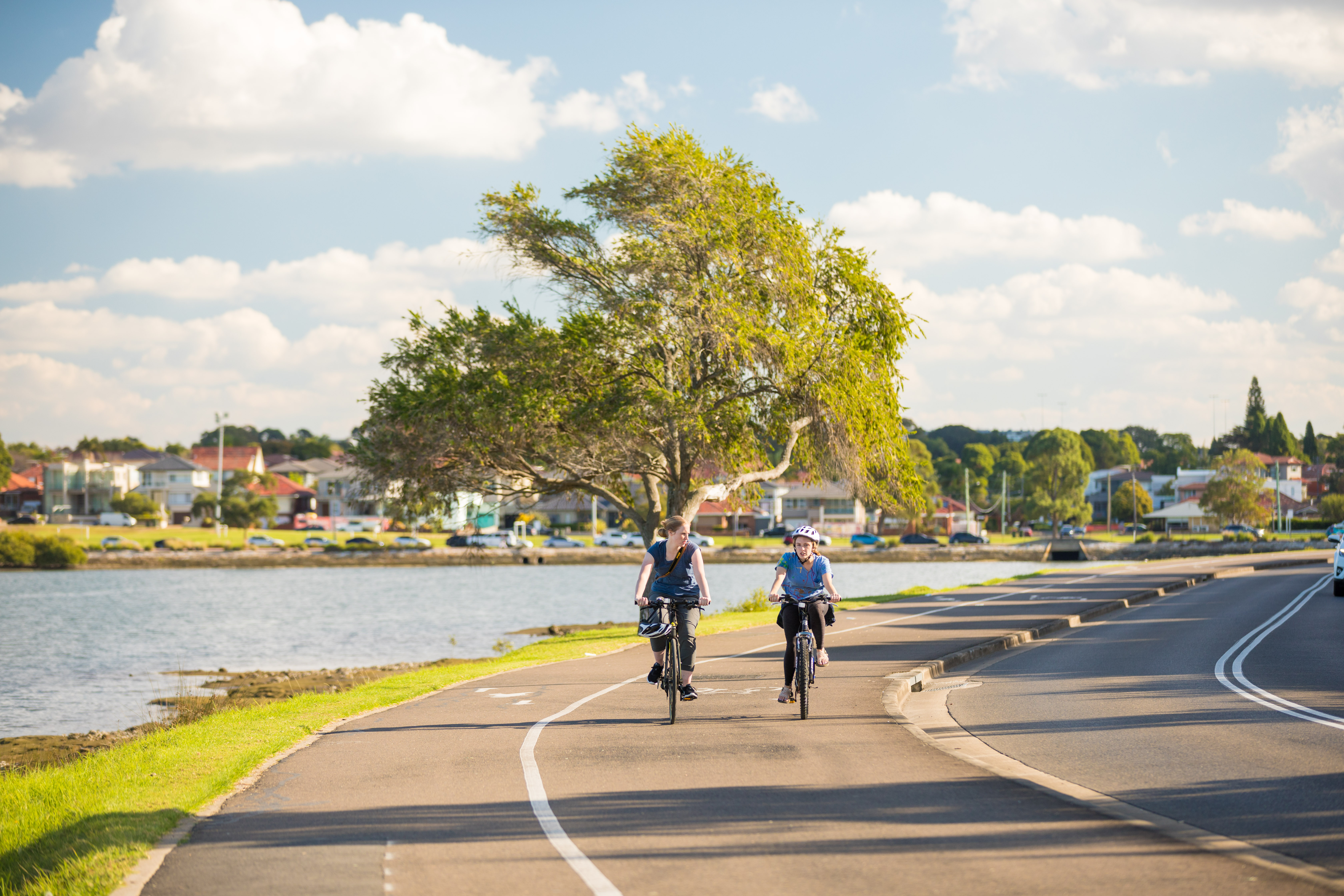 Image of two people cycling on a road