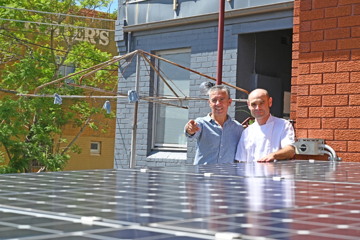 Image of business owner and Mayor with solar panels