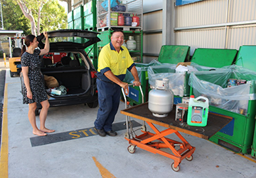 Image of staff and member of public at community recycling centre