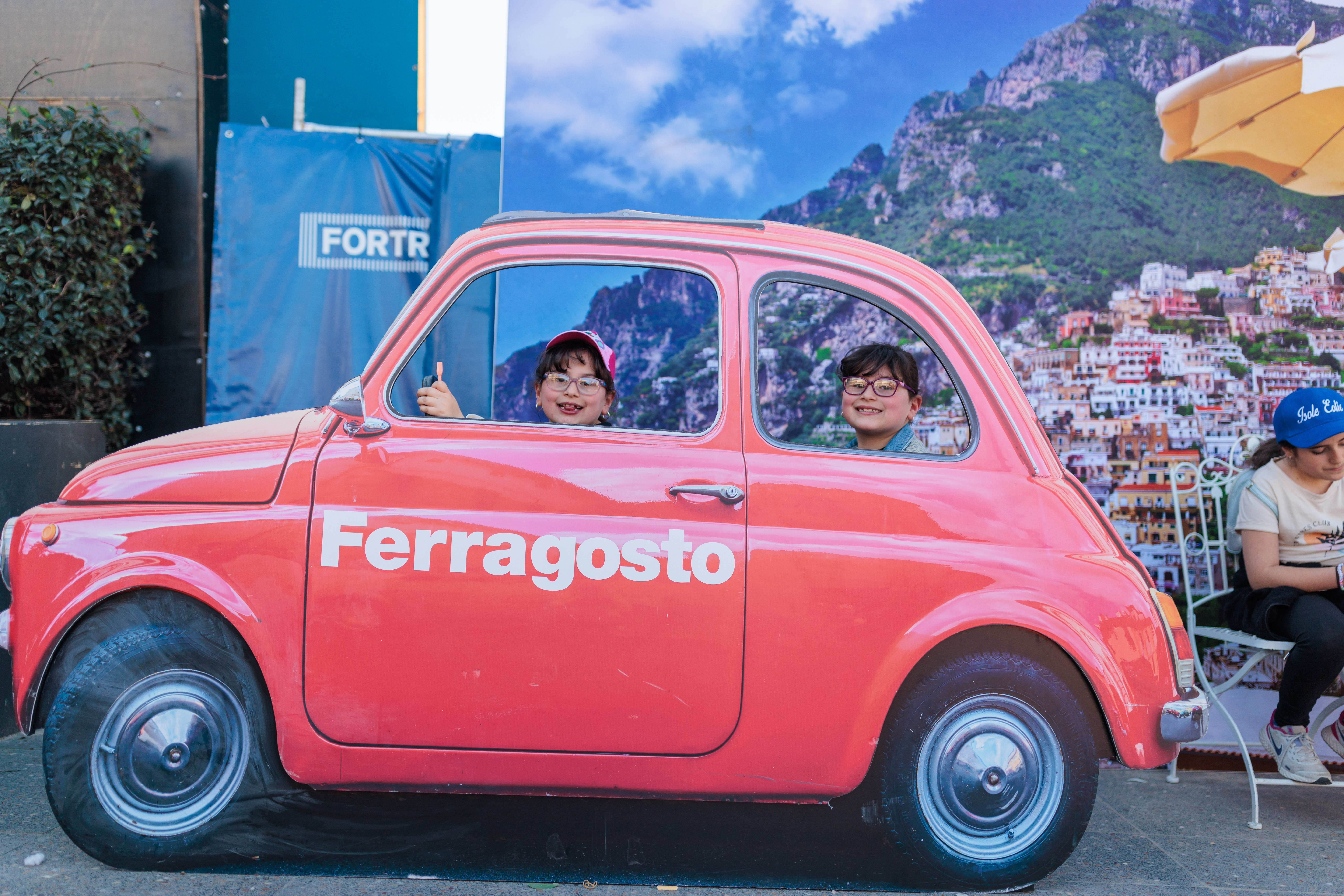 kids posing with ferra car stand