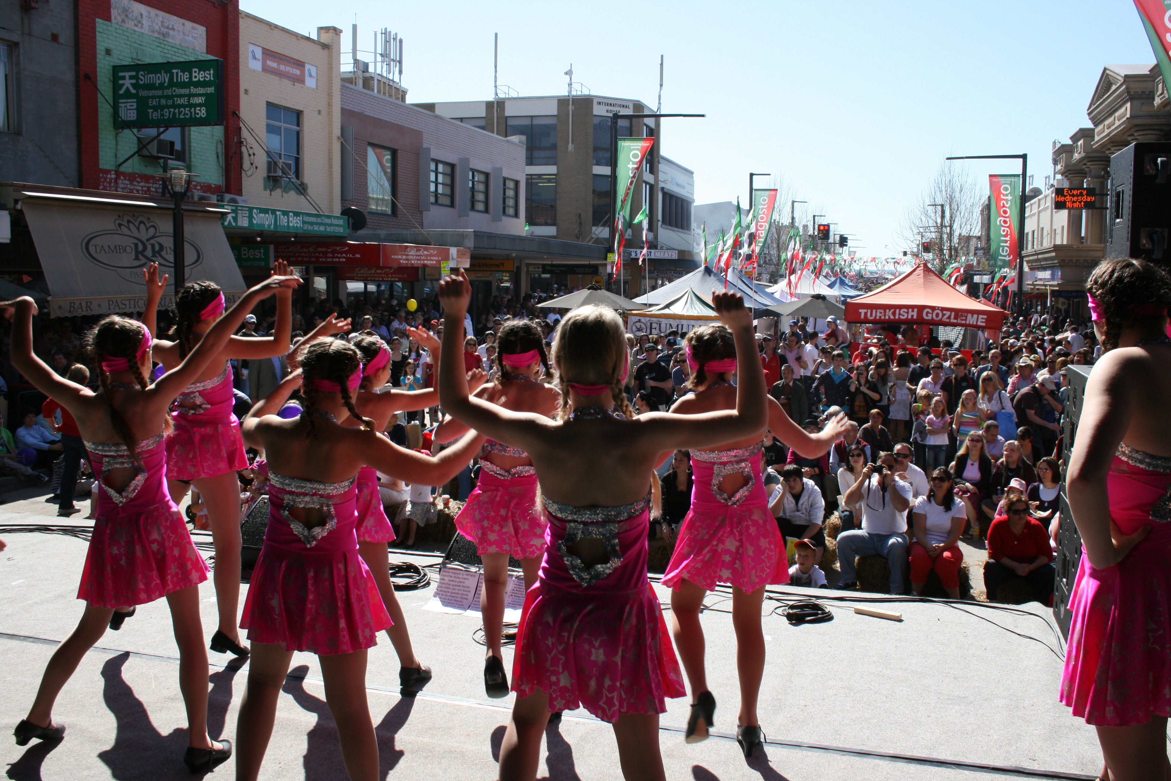 girls performing on stage in front of crowd