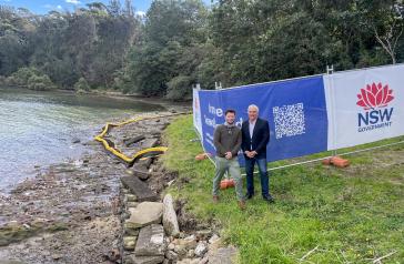 Mayor and Council staff member in-front of Iron Cove Seawall in need of repair