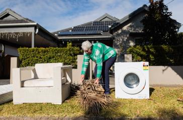 Woman putting branches out for Bulk Household Waste Collection