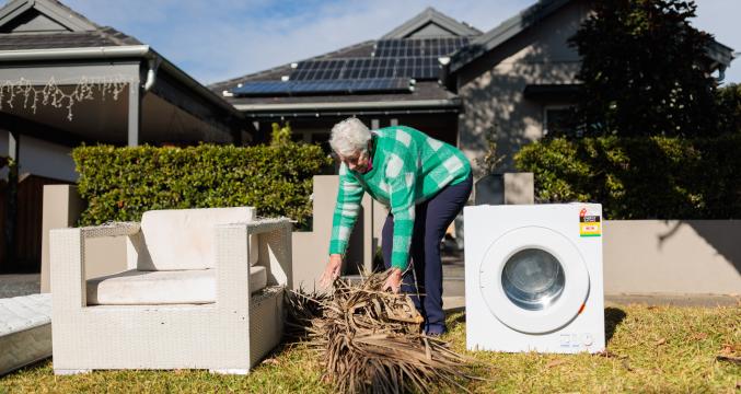 Woman putting branches out for Bulk Household Waste Collection